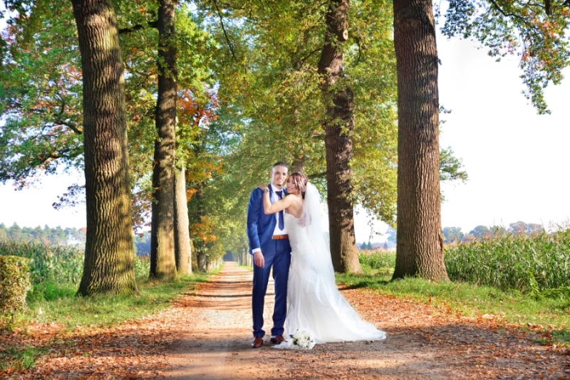 Bruidspaar in een laan met bomen