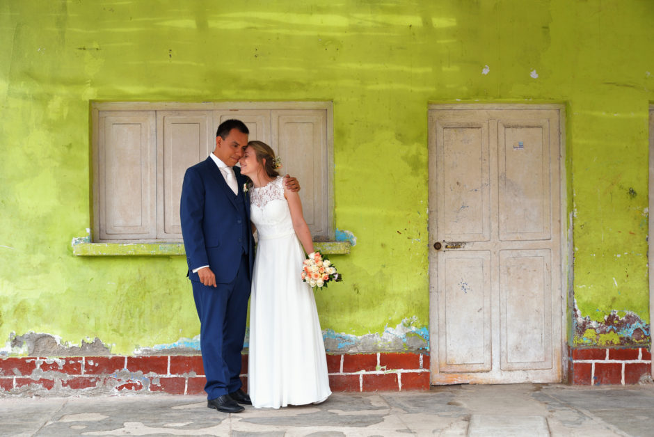 Bruidspaar bij een kleurige muur in Peru tijdens hun destination wedding in Zuid-Amerika. De fotograaf uit Nederland is meegereisd.