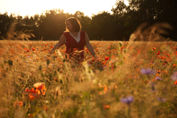 Creatief portret van een meisje tijdens een fotoshoot in een bloemenveld in Limburg.