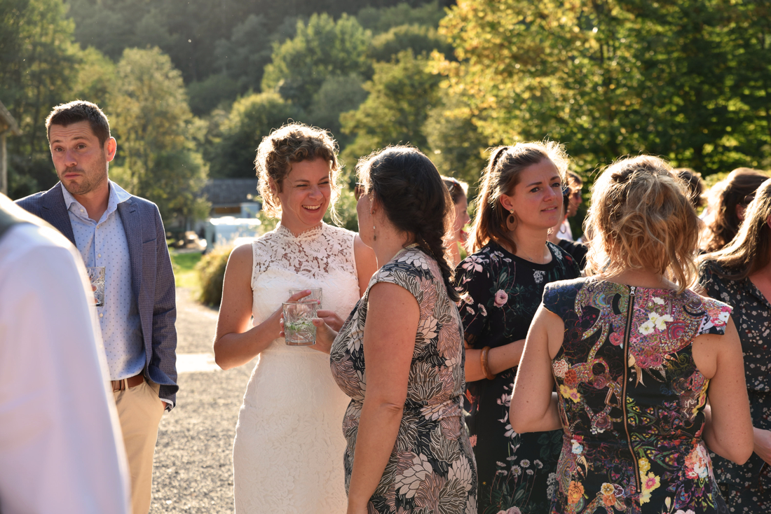 Gezelligheid op een Bruiloft in de Ardennen tijdens het gouden uurtje genieten van een borrel. De bruidsfotograaf komt uit Nederland en is meegereisd.