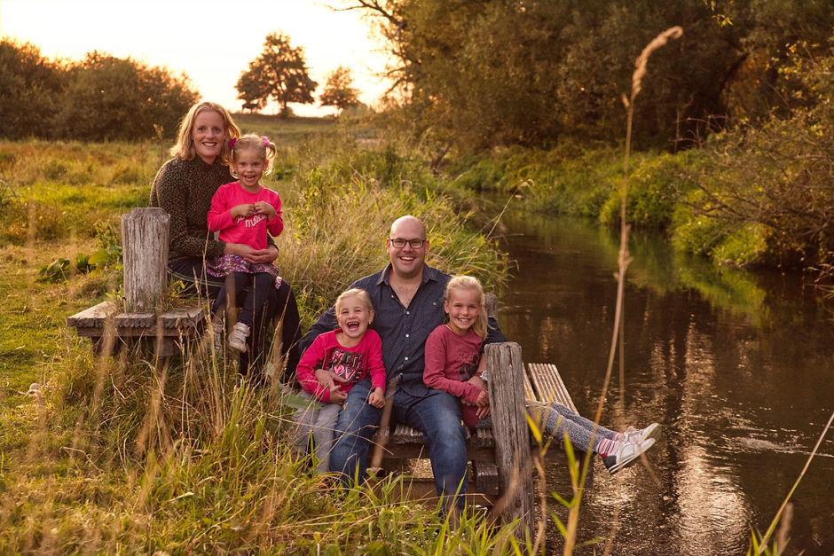 Een vrolijke foto van een gezin tijdens hun foto reportage in Roermond aan het water, vastgelegd door een fotografe uit Limburg.