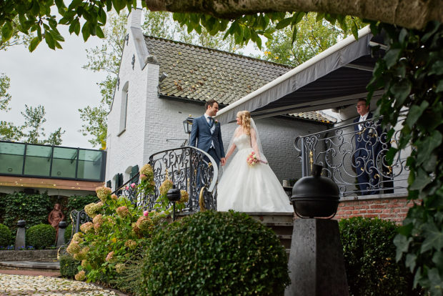 De bruid wordt opgehaald door haar bruidegom. Op een bruiloft bij kasteel groot Buggenum te Grathem in Limburg. De bruidsfotograaf komt uit Roermond. 