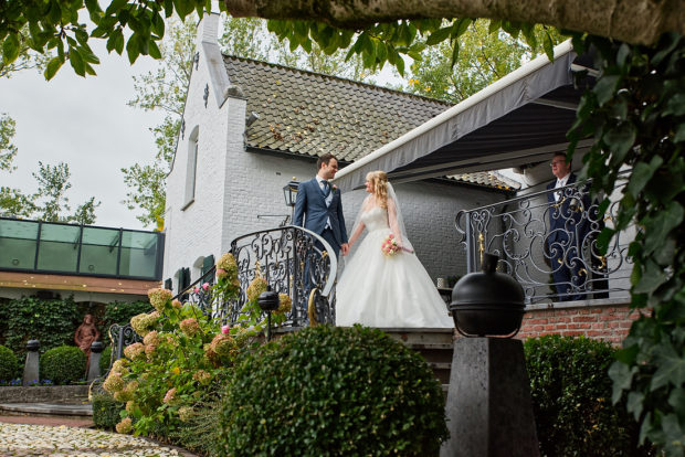 De bruid wordt opgehaald door haar bruidegom. Op een bruiloft bij kasteel groot Buggenum te Grathem in Limburg. De bruidsfotograaf komt uit Roermond.