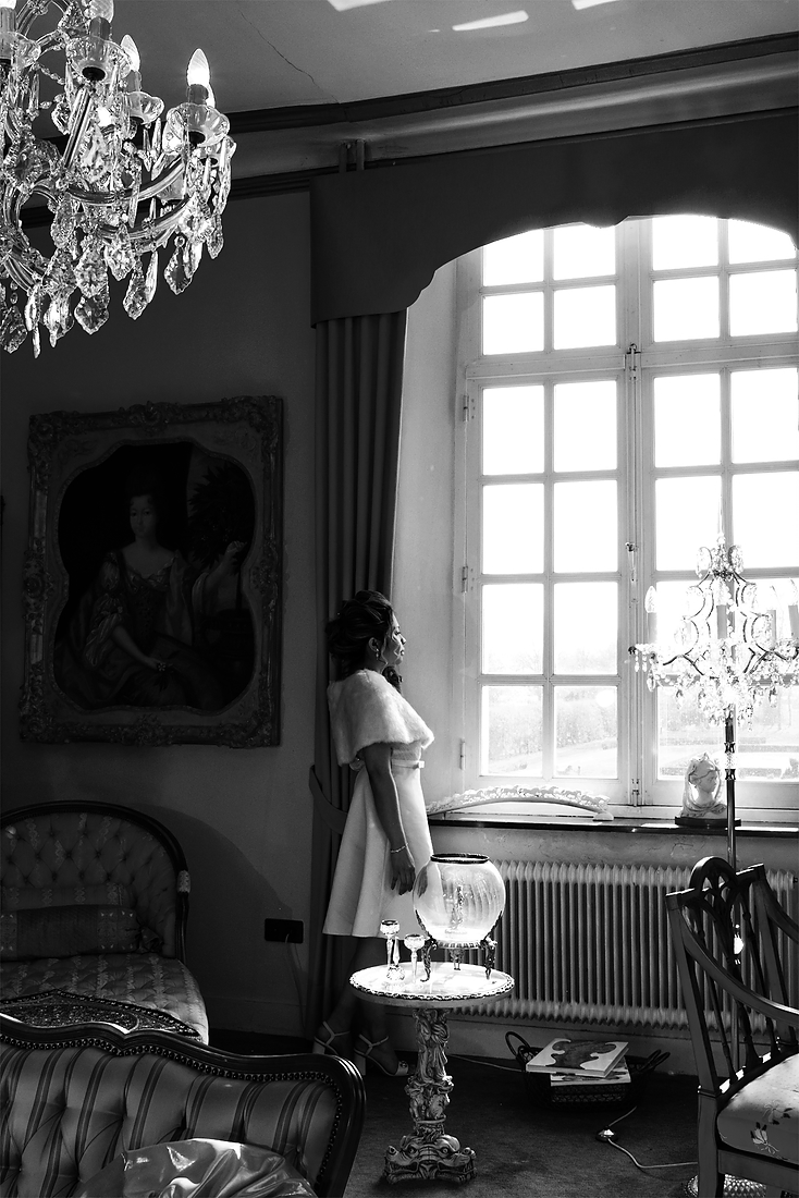 Zwart wit foto van een bruid bij het grote raam. In kasteel Aldenghoor te Healen. Het bruidspaar heeft een fotoreportage laten maken. De fotograaf komt uit Roermond.