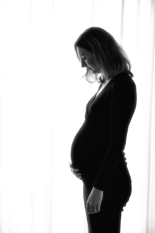Een foto van een zwangerschap, een silhouet zwart wit foto bij de ouders thuis. 