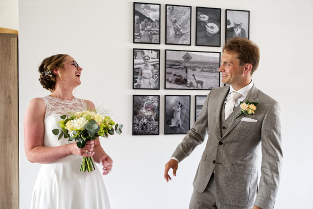 Bruidsfotografie is altijd leuker vanaf de first look. Hier in Limburg, een bruidspaar dat spontaan aan het lachen is, nadat ze elkaar net voor het eerst in trouwkleding gezien hebben.