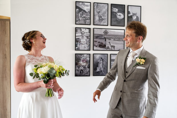 Bruidsfotografie is altijd leuker vanaf de first look. Hier in Limburg, een bruidspaar dat spontaan aan het lachen is, nadat ze elkaar net voor het eerst in trouwkleding gezien hebben.