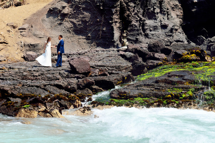 Bruidspaar op de rotsen bij het strand in Peru.