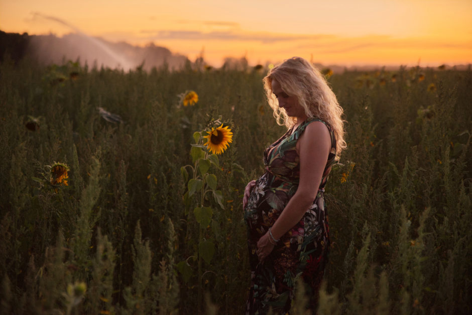 Zwangerschapsfoto in een veld met bloemen in Limburg
