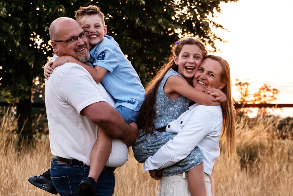 Vrolijke foto van een gezin door een fotograaf uit Limburg tijdens de zonsondergang.  Als Familiefotograaf maak ik nu vaak een reportage van een familie die op vakantie is in Limburg . Bijvoorbeeld bij een vakantiehuis van de Smockelaer.