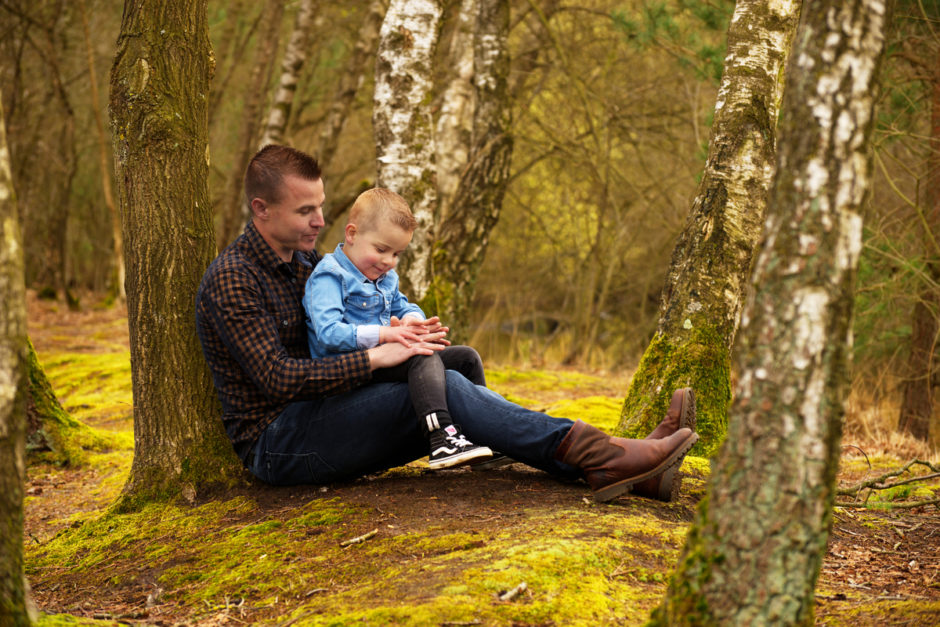 Vader en zoon zitten bij elkaar in de natuur tijdens een fotoshoot in Limburg