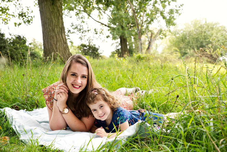 Mama en dochter liggen op een dekentje tijdens hun fotoshoot in Limburg.