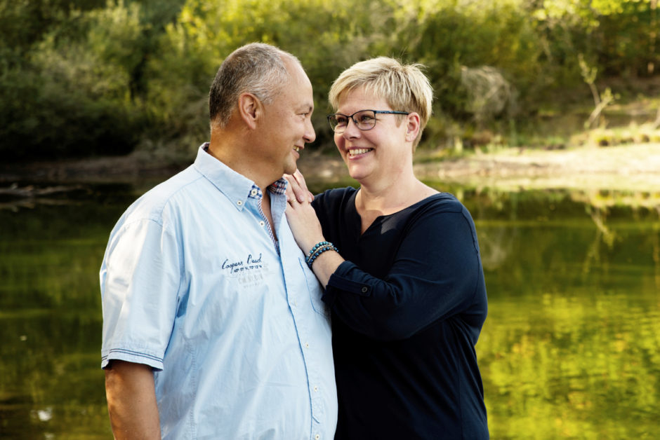 Koppel wandelt en kijkt naar elkaar in de natuur tijdens de fotoshoot van de familie in Limburg.