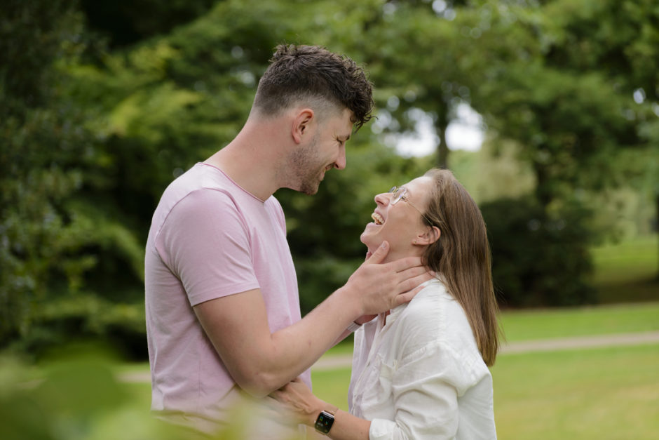 Koppel moet lachen omdat de fotograaf ze grappige opdrachtjes geeft.