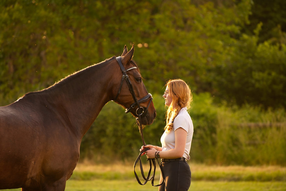 Portret van een meisje en haar paard in Limburg bij het golden hour, vlak voordat de zon ondergaat.