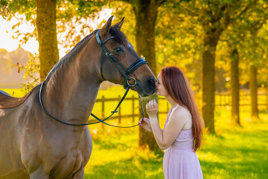 Vrouw geeft haar paard een kusje bij een fotoshoot in Limburg. Met prachtige herfst kleuren.