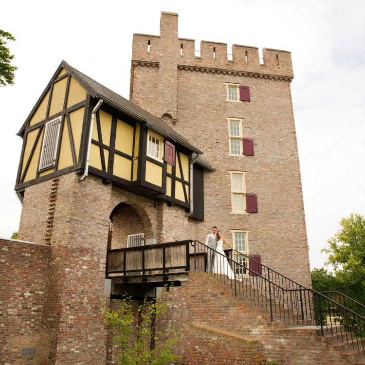 Trouwen bij een kasteel in Limburg. Bruidspaar op de trappen bij Kasteel Daelenbroeck in Herkenbosch bij Roermond.