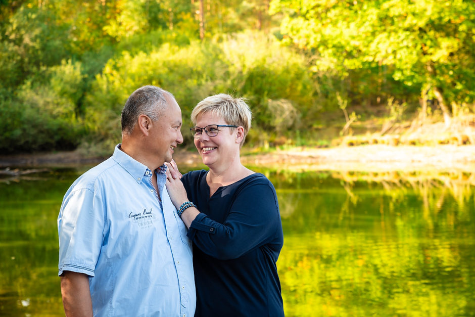 romantische foto van een koppel dat bij het water in het bos in Limburg staat, gemaakt tijdens een fotoshoot van de hele familie.