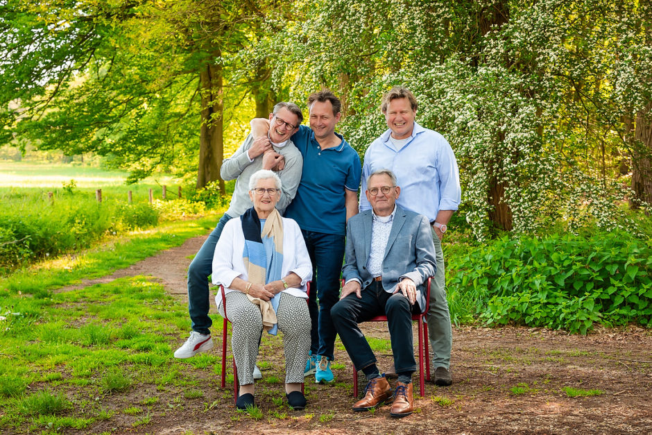 Opa en oma met drie zoons staan  ontspannen op de foto tijdens een spontane fotoshoot met leuke opdrachten in Limburg door een fotograaf uit Roermond.