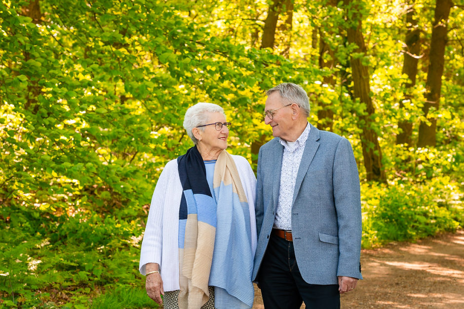 Opa en oma lopen op een bospad tijdens een spontane fotoshoot met leuke opdrachten in Limburg door een fotograaf uit Roermond.