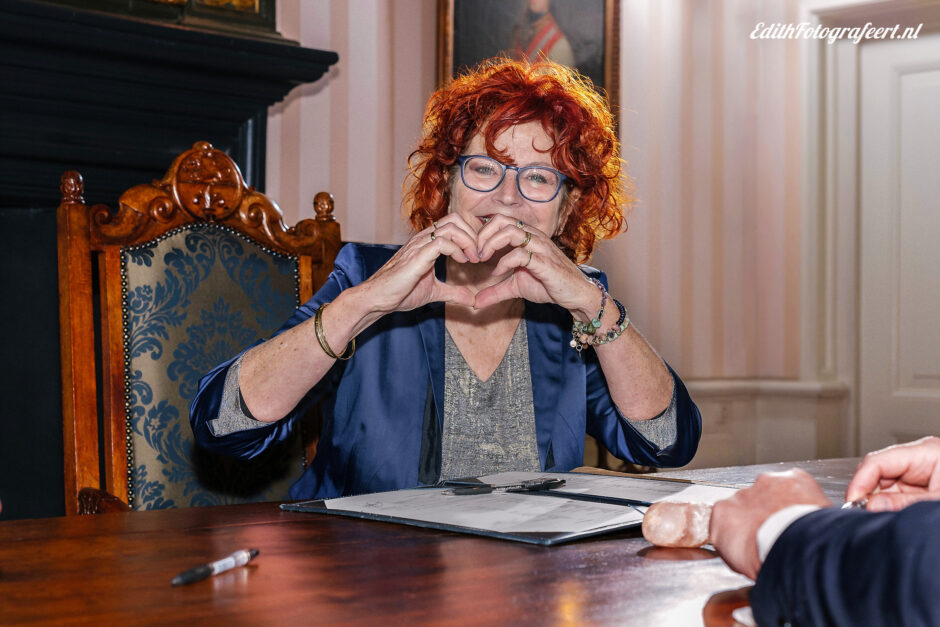 De leukste trouwleveranciers. Op deze foto staat Agnes Stijnen die tijdens de ceremonie een hartje vormt met haar handen.